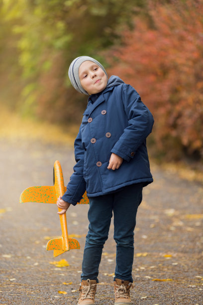 男孩在公园里玩，手里拿着飞机，开始和欣喜，秋天，概念图片下载