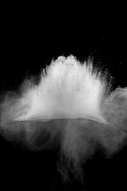 在黑色的背景下出现了奇异的白色粉末爆炸云。白色灰尘颗粒飞溅。图片下载