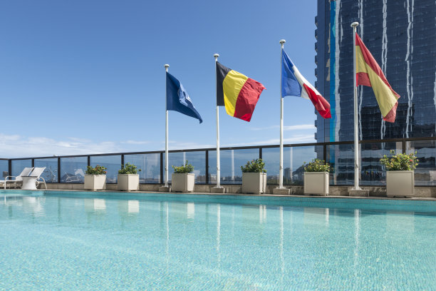 在豪华酒店的游泳池后面挥舞旗帜图片下载