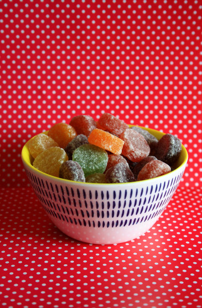 一个彩色的糖果碗，有红色的斑点背景图片下载