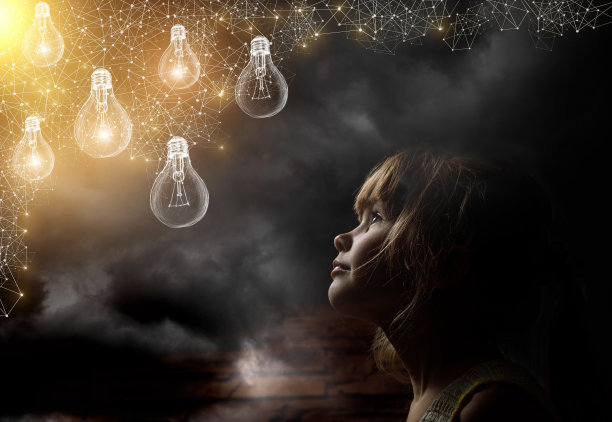一个孩子正在看燃烧的彩色灯泡。素材图片