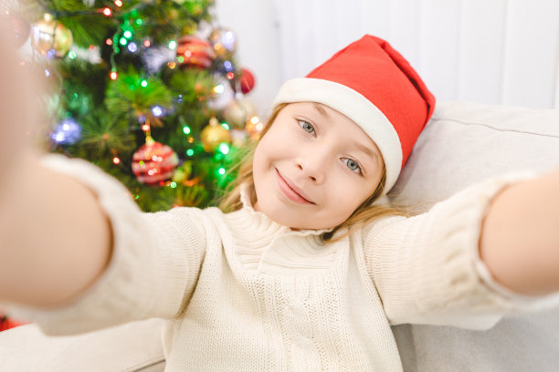 那个戴着圣诞老人帽的可爱小女孩拿着照相机图片下载