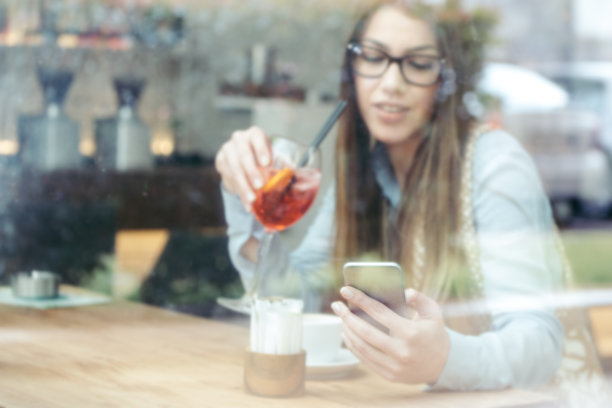 时尚女商人在酒吧里用手机。专注于手机。图片下载