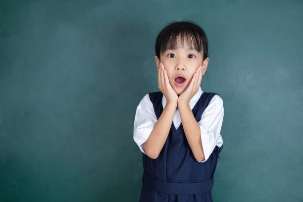 亚洲华人小女孩表现出惊讶的表情，手放在下巴图片下载