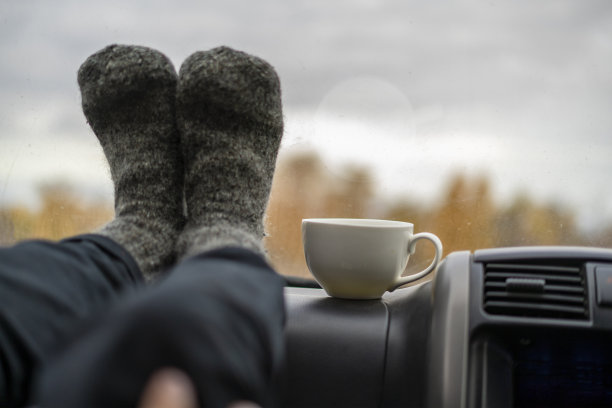 闭上女人的腿在温暖的羊毛袜子在车和喝茶f图片下载
