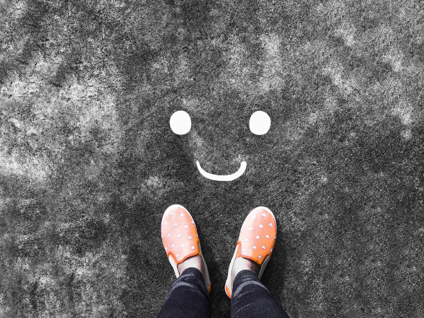 微笑的脸在路上和粉色运动鞋的背景图片下载