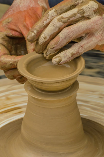 这是艺术家创作陶罐的手的特写，这是制作陶瓷产品的传统方法图片下载