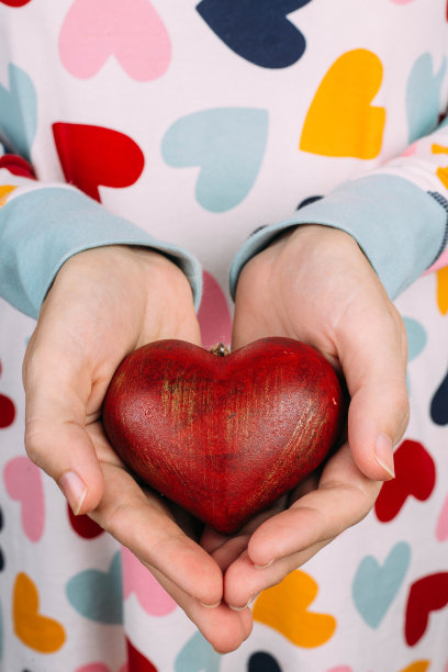 女人的手捧着红心。情人节的概念。带有复制空间的设计图片下载