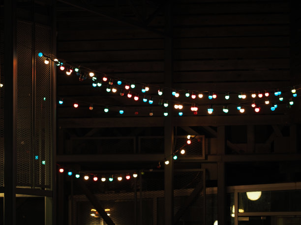 节日装饰用的五颜六色的灯泡。抽象的背景。多色灯泡花环在黑暗的城市背景图片下载