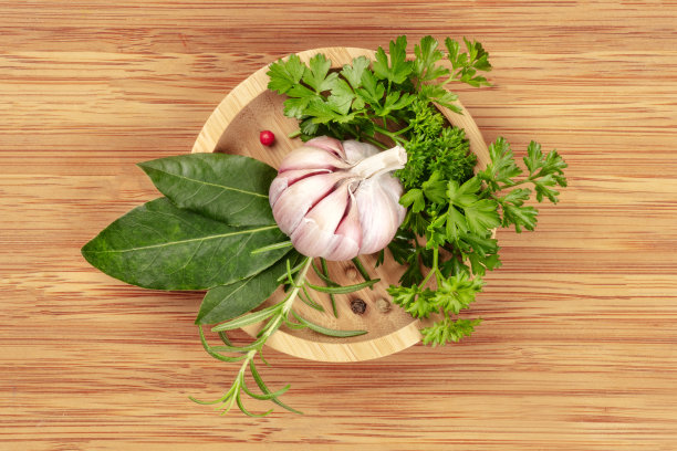 头顶上的照片，大蒜，芳香的厨房香草和香料，从顶部拍摄在一个木碗，在一个质朴的木制背景和文字的地方图片下载