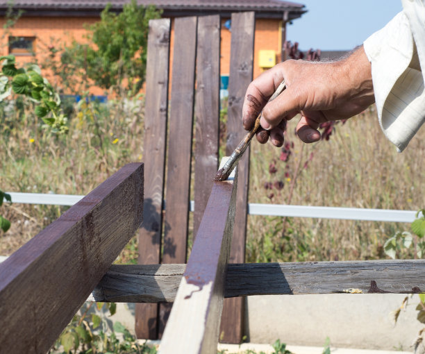 手握画笔，在木桌上作画。图片下载