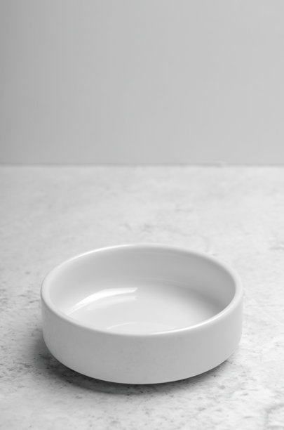 一个干净的小白色盘子在轻石背景。简约的厨房,菜肴。副本的空间。图片下载