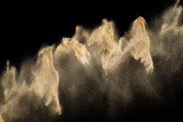 金色的沙子爆炸孤立在黑色的背景。抽象的沙子云。图片下载