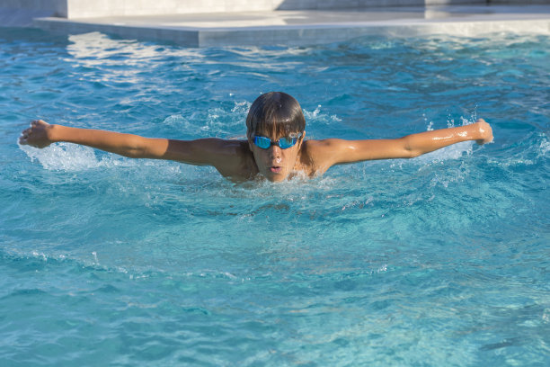 少年的特写动作镜头，年轻的athlethе蝶泳。图片下载