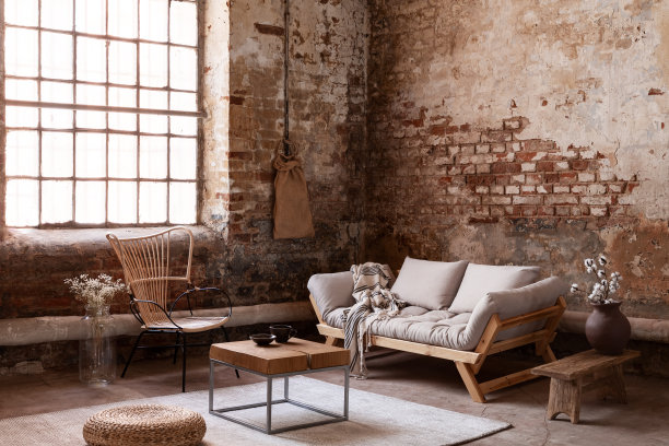 扶手椅在米色沙发在客厅内部在侘井风格与花在桌子和窗户上。真实的照片图片下载