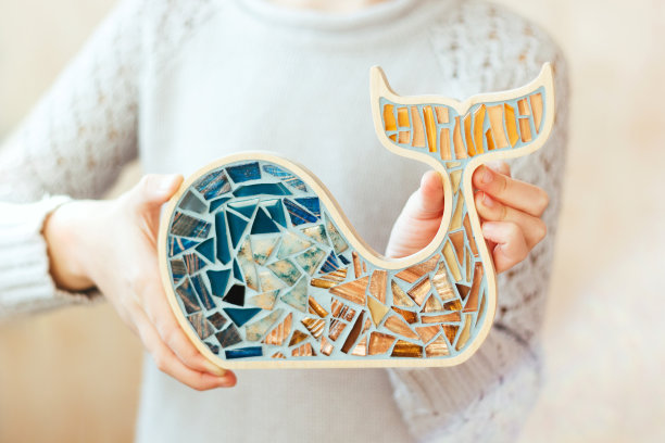 女孩手里拿着一条马赛克鲸鱼。图片下载