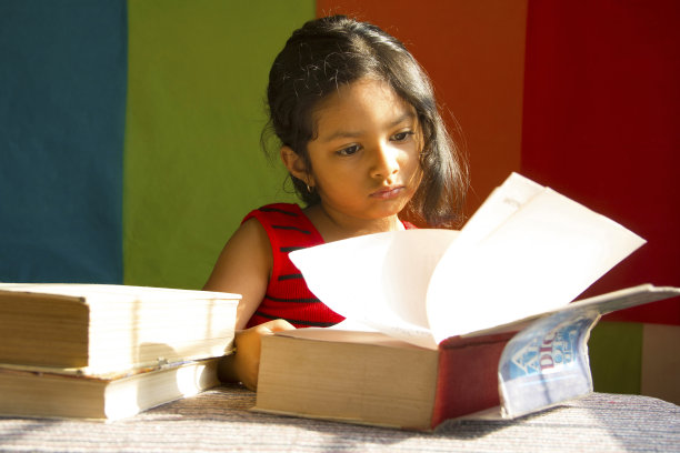 印度浦那的小女孩像个学者一样读着大书图片下载