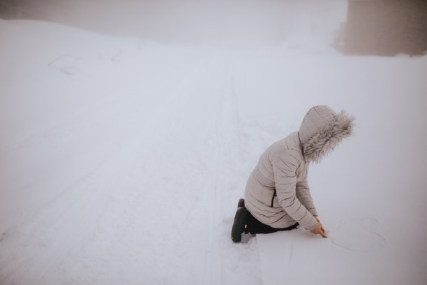 在雪中画心形的女人图片下载