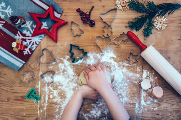 小女孩们在木桌上用手揉着圣诞饼干面团图片下载