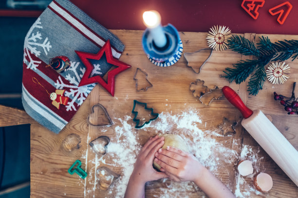 小女孩们在木桌上用手揉着圣诞饼干面团图片下载