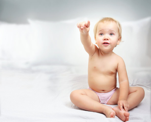 孩子在床上显示手指空白。托儿所的概念。图片下载