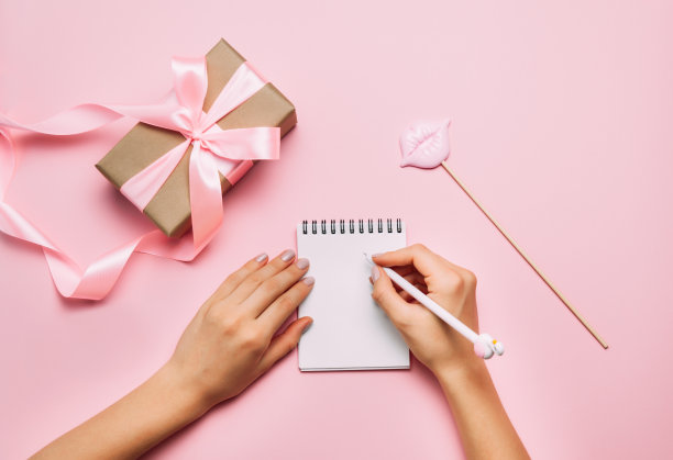 美丽女性的手与时尚美甲书写在笔记本上图片下载