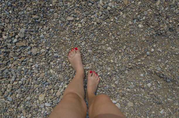 女人的脚踩在石头上图片下载