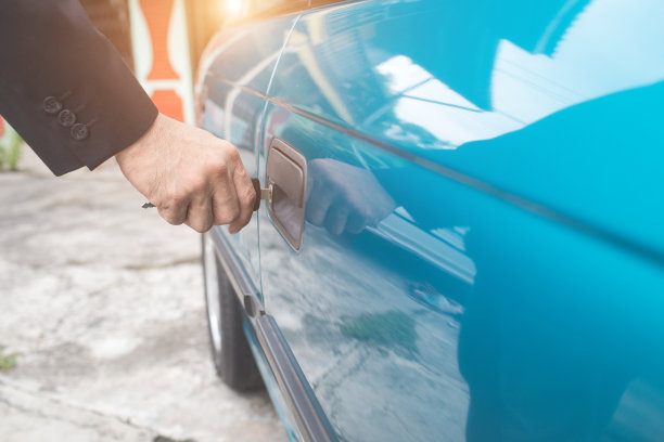 商人用钥匙手动打开或锁住旧车门图片下载