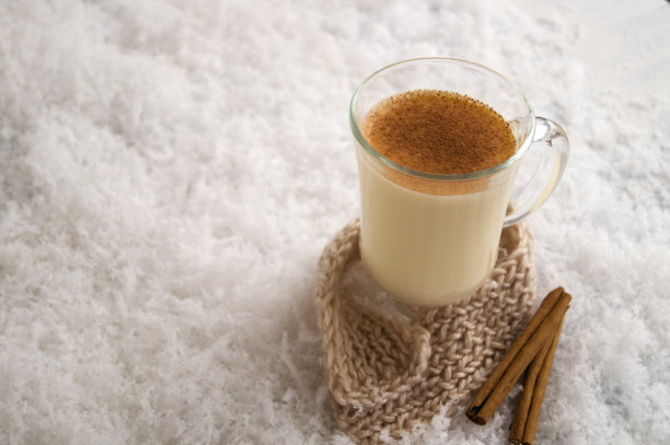 圣诞鸡尾酒蛋酒在一个明亮的背景，在一个玻璃杯。图片下载