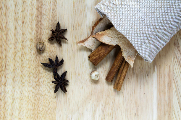 肉桂棒，香料和干姜袋放在木桌上图片下载