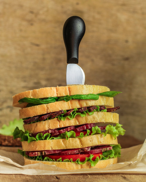 三明治-面包，肉，罗勒，新鲜的莴苣叶在木制的背景。前视图。本空间图片下载