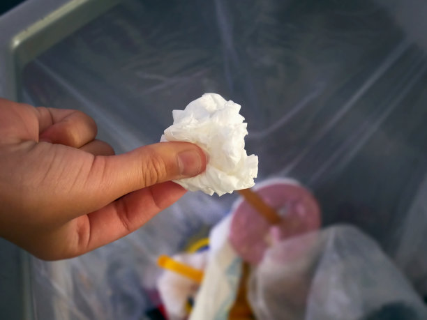 在把用过的纸巾扔进垃圾桶前，手扶着它图片下载