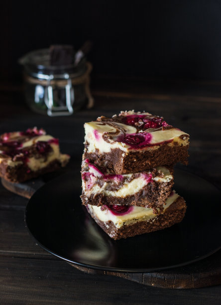 巧克力芝士蛋糕，分层的布朗尼和黑樱桃。红巧克力蛋糕。几块巧克力蛋糕。冬天的甜点。传统的美国菜。食物的静物。黑色食物的照片。图片下载