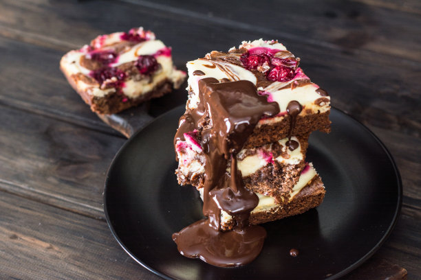 巧克力芝士蛋糕，分层的布朗尼和黑樱桃。红巧克力蛋糕。几块巧克力蛋糕。冬天的甜点。传统的美国菜。食物的静物。黑色食物的照片。图片下载
