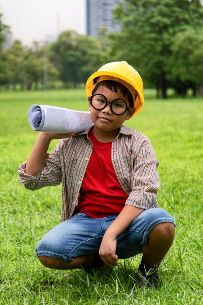 亚洲男孩在红色衬衫有乐趣的角色扮演作为一个工程师在公园里图片下载