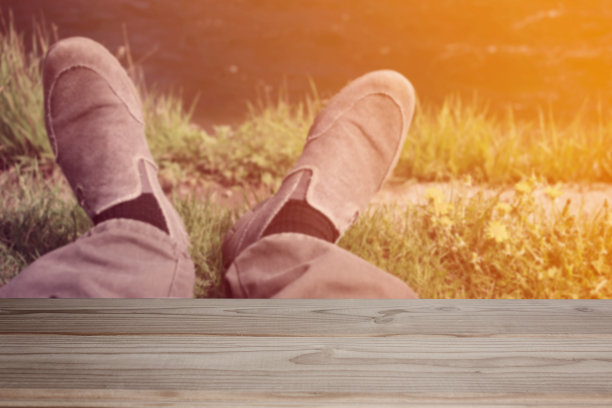 空木桌的背景上休息的人的脚在夏天的自然图片下载