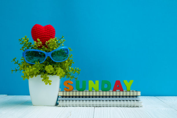 周日信件文本和笔记本纸和小装饰树在白色花瓶上木制背景，你好周日周末的概念。图片下载