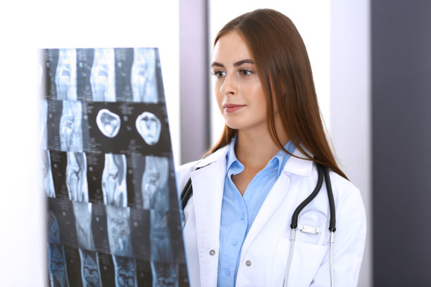 一位女医生站在医院窗户附近检查x光照片。在工作中的外科医生或整形外科医生医疗保健理念图片下载