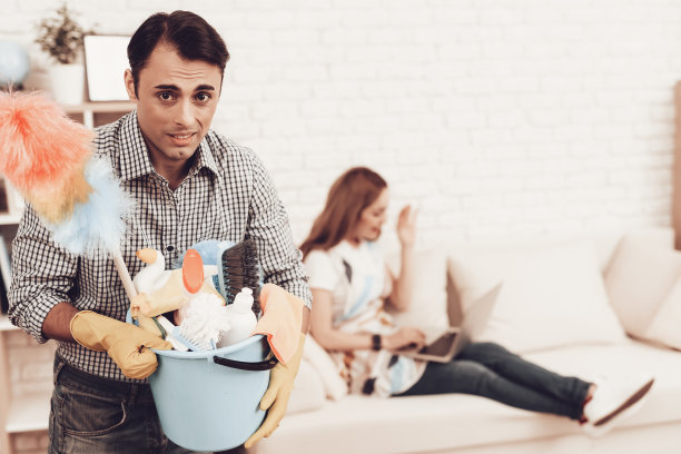 男人与清洁配件清洁公寓。图片下载