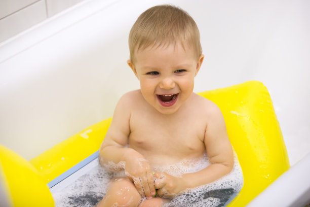 兴奋可爱的宝宝有乐趣与泡沫洗澡在浴室图片下载