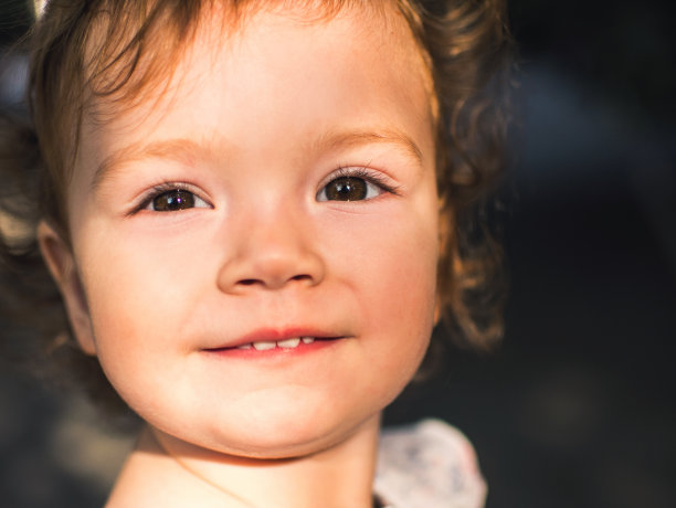 一个美丽的蹒跚学步的女孩的肖像。一个漂亮的卷发小孩的户外照片图片下载