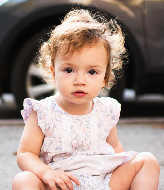 一个美丽的蹒跚学步的女孩的肖像。一个漂亮的卷发小孩的户外照片图片下载