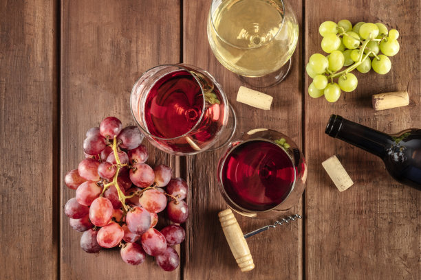 复古酒窖品酒会。这是一张由红、玫瑰、白葡萄酒和酒瓶、葡萄、老式瓶塞组成的玻璃杯的照片，从顶部拍摄，背景是带有复制空间的深色乡村木制背景图片下载