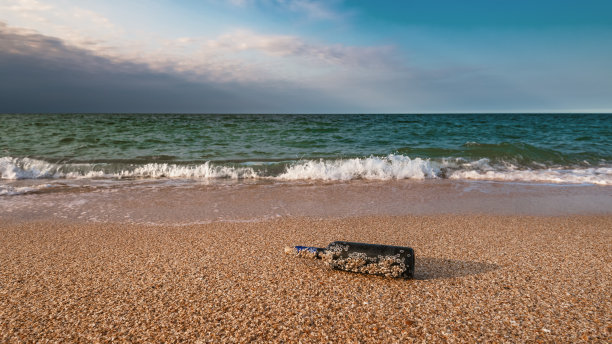 空无一人的海滩上，塞在瓶子里的信息图片下载