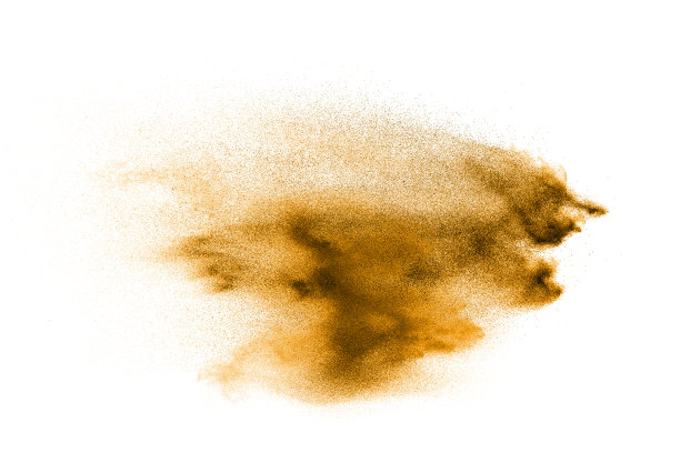干河沙爆炸。金色的沙子溅在白色的背景上。图片下载