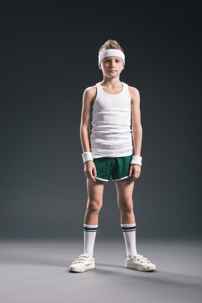 十来岁的男孩穿着网球运动服看着灰色背景的相机图片下载