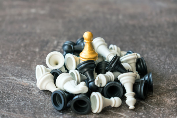 领头的金卒站在一堆倒下的棋子上，在黑暗的背景下下棋。赢家，企业战略，胜利，成功，相信自己，力量，领导力图片下载