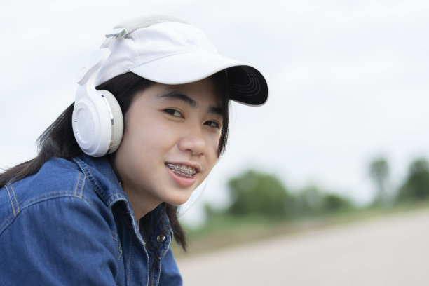 孤独的年轻女孩听着音乐。图片下载