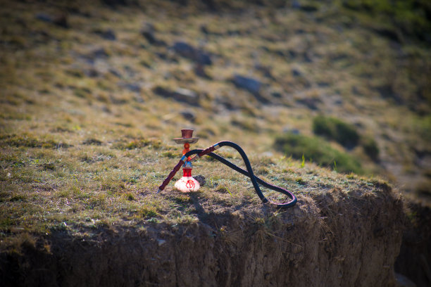 水烟，传统阿拉伯水管，直接日落光，户外照片。山的背景或水烟的剪影在日落的背景。户外。有选择性的重点图片下载