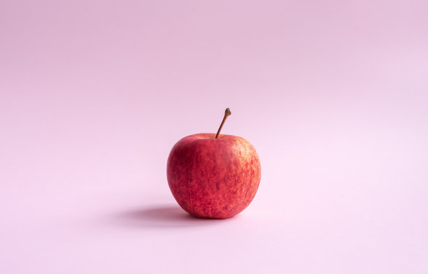 红色的gala苹果在粉红色的背景图片下载